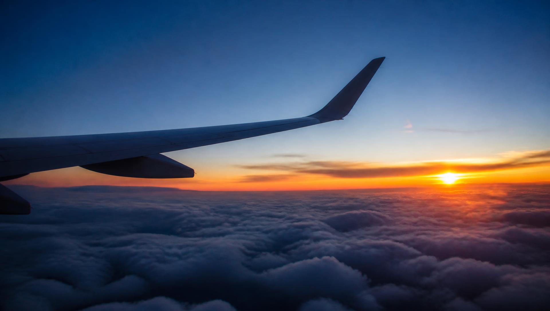 Aircraft wing above the clouds during a sunset flight